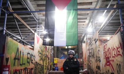 En polis under en palestinsk flagga efter en räd mot demonstranter som ockuperat University of Los Angeles campus. Bild tagen den 2 maj.